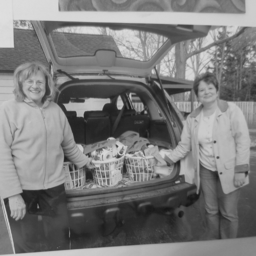 Nancy Cerny and Maria Knickerbocker in front of a car with cleaning supplies to distribute